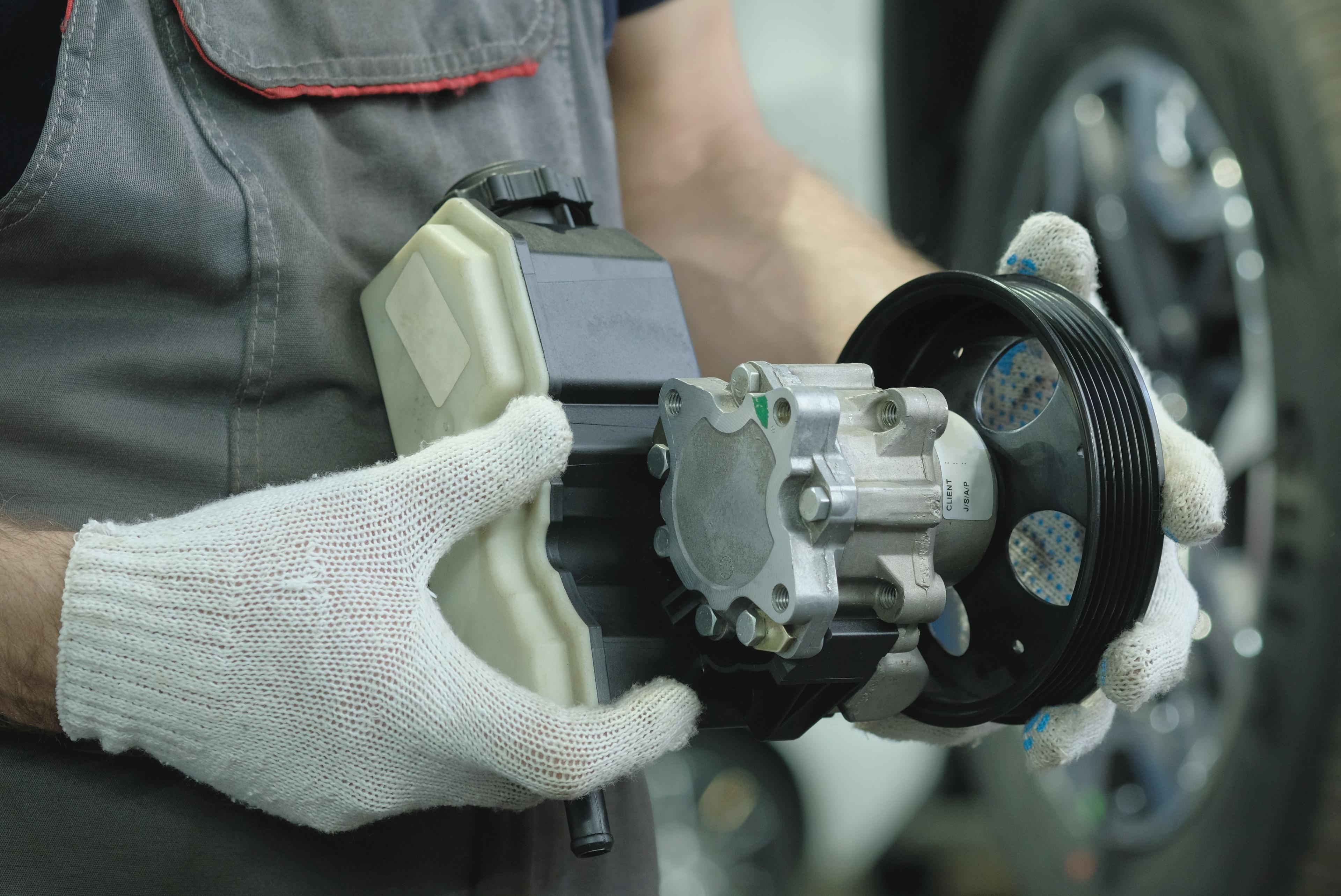 Mechanic holds a new fuel pump