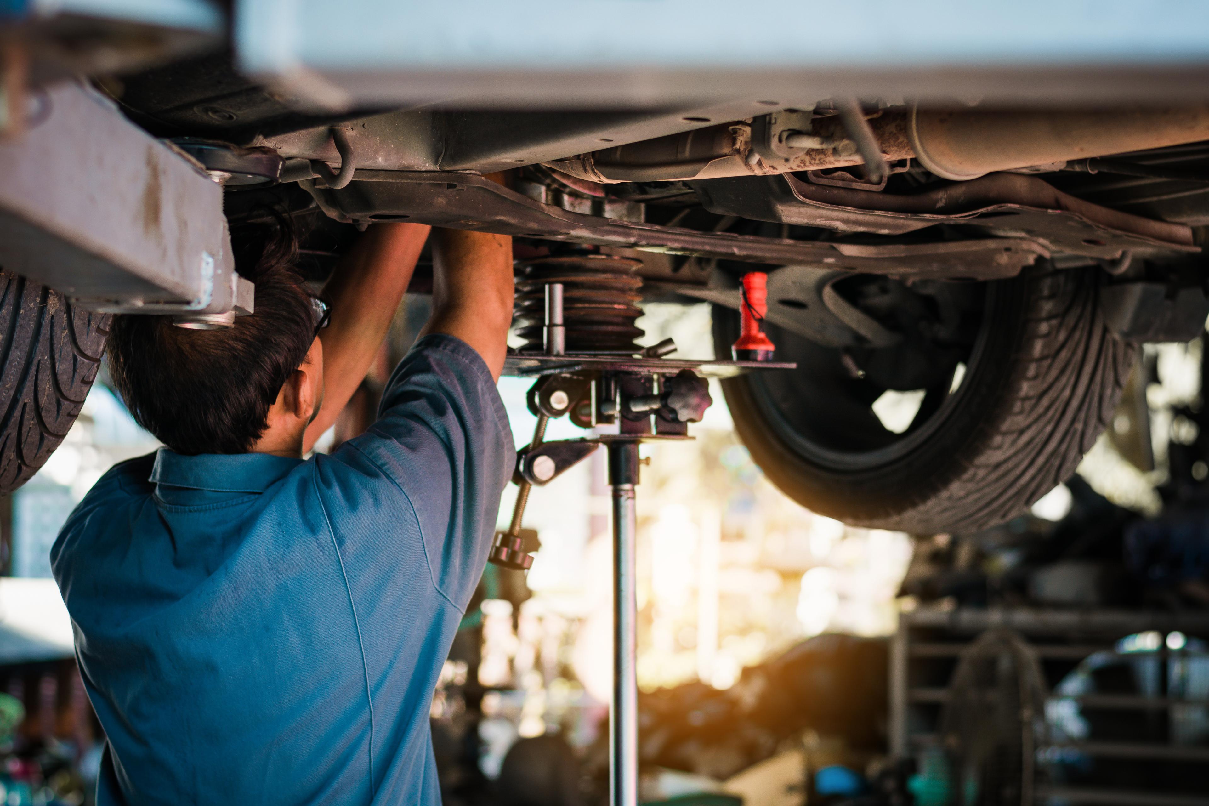 Mechanic performs catalytic converter replacement