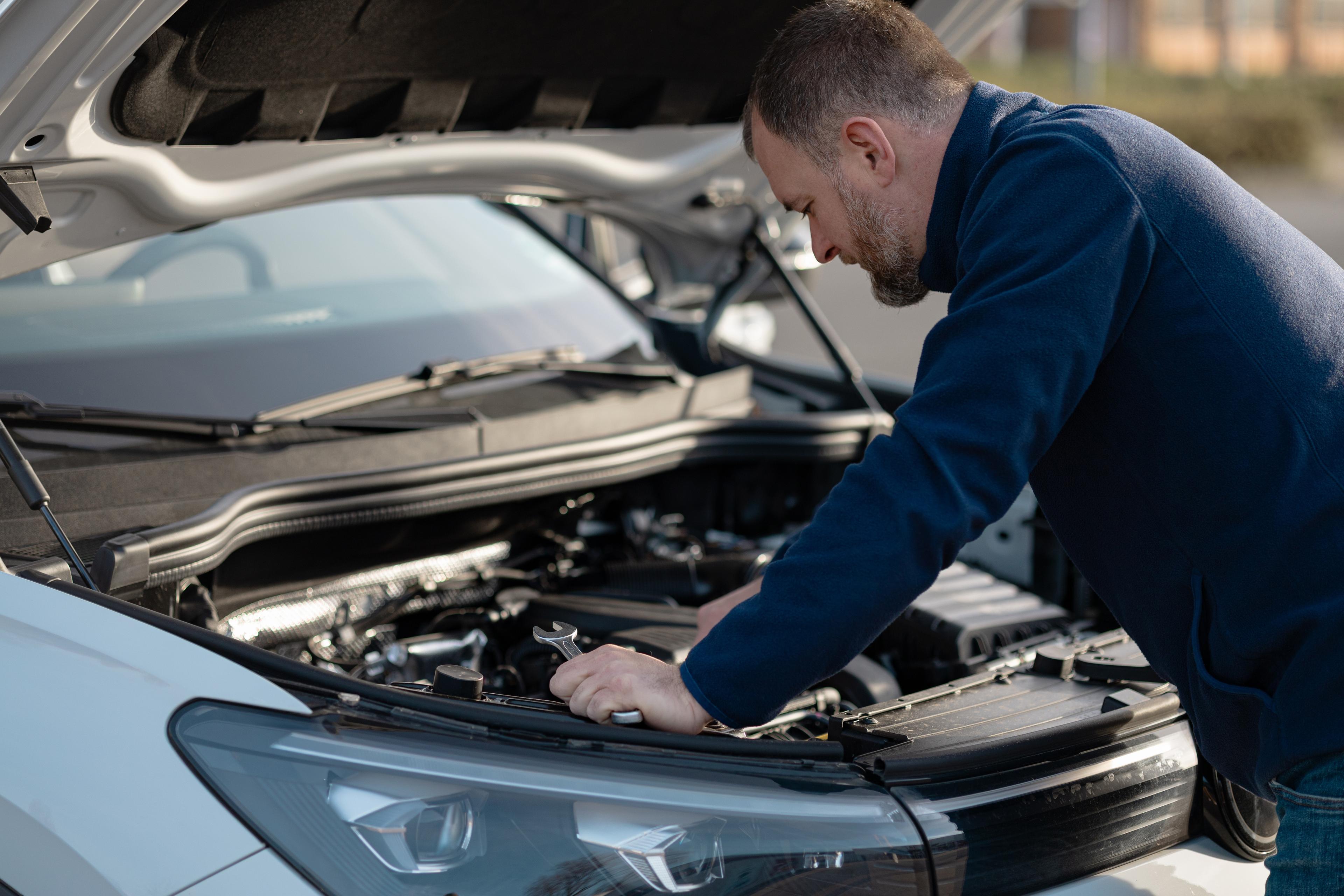 Mechanic performs car repair in engine bay